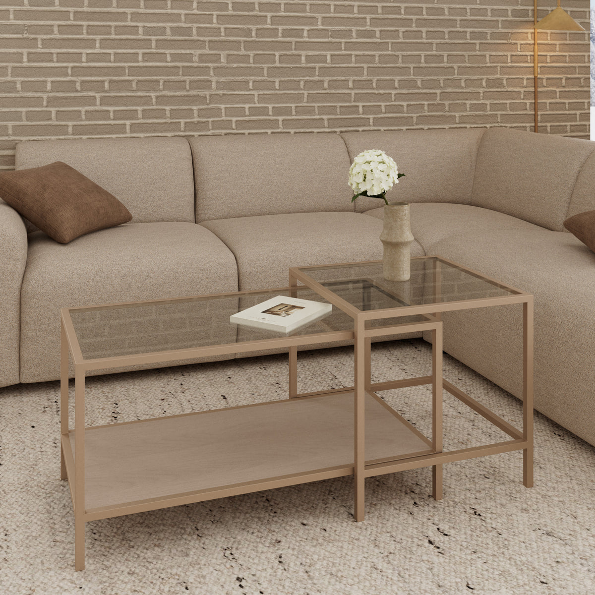 Et sæt Skeleto-sofaborde i størrelserne 90x45 og 50x50 foran en beige hjørnesofa, en murstensvæg og en vase med blomster