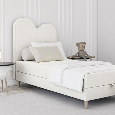 Mellia-børneseng i størrelserne 90x160 og 90x180, kontinental model med bølget hovedgærde og opbevaringsrum i soft modern-stil – i indretningen