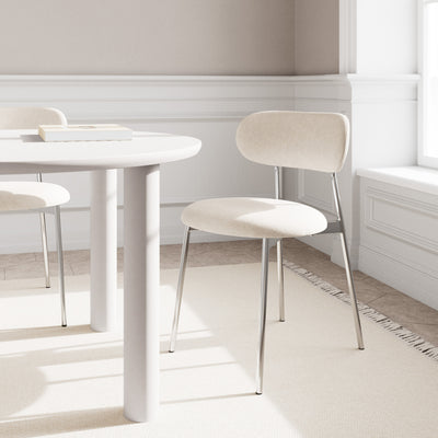 Dotto-stole 47x79 i farven Sand ved et hvidt, rundt bord i en lys spisestue med vindue – stole i retrostil