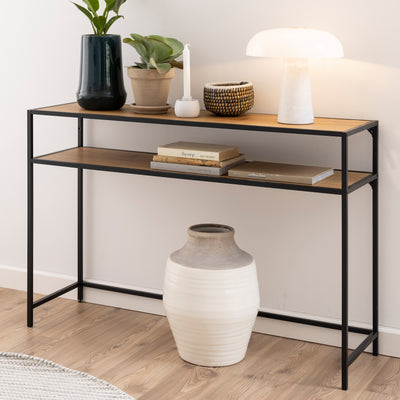 Skeleto-konsol 120x79 i vild eg ved en lys væg med en lampe, planter og bøger på hylden – en konsol til entreen